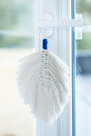 Plume en macramé beige suspendue à une poignée de porte