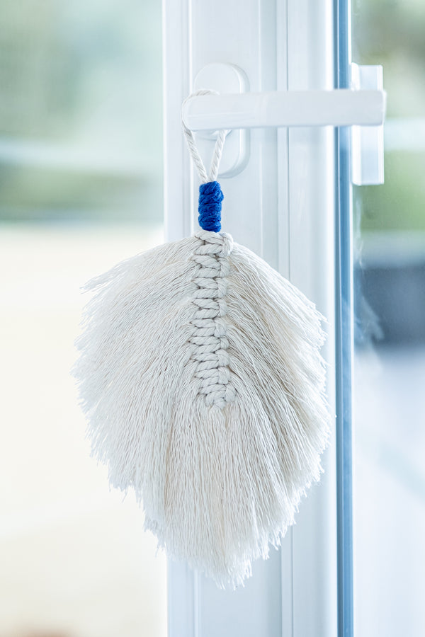 Plume en macramé beige suspendue à une poignée de porte
