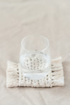 Deuxième face d'un dessous de verre réversible en macramé avec un verre d'eau