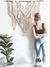 femme et son chien devant un grand macramé et une plante en pot