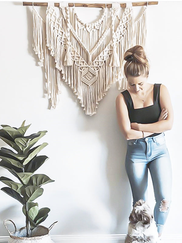 femme et son chien devant un grand macramé et une plante en pot