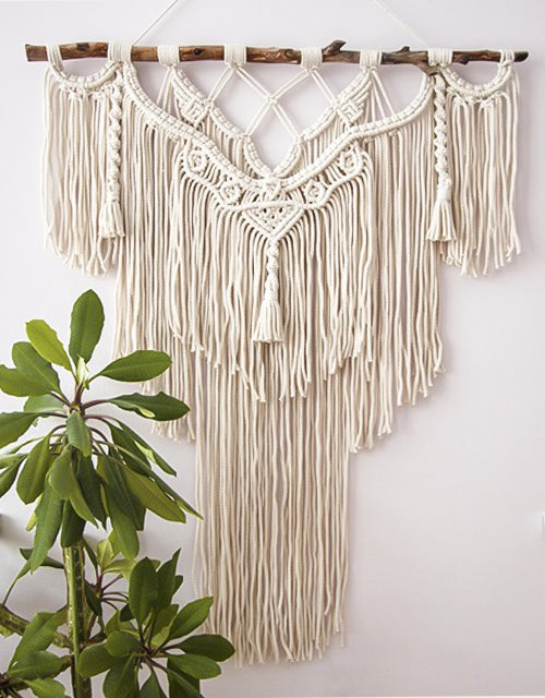 macramé mural suspendu sur du bois naturel