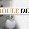 3 boules de noel en macramé à côté d'une bougie allumée