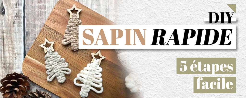 trois sapin en macramé sur une table en bois avec une pomme de pin